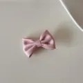 Gros plan d'une élégante pince à cheveux nœud en satin rose à la texture soyeuse - Pinces à cheveux bec de canard / S / Rose