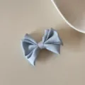 Vue détaillée d'une barrette à nœud en satin bleu clair élégante avec texture de soie - Pinces à cheveux bec de canard / L / Bleu
