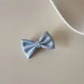 Vue détaillée d'une élégante pince à cheveux avec nœud en satin bleu clair, texture douce. - Pinces à cheveux bec de canard / S / Bleu