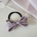 Gros plan d'un chouchou en tissu à pois lavande avec un joli nœud papillon - Violet