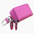 Vista macro dettagliata della custodia per chiavi auto in pelle rosa con doppia cerniera - Rosso rosa
