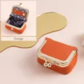 Compact orange leather jewelry storage bag with elegant gold kiss lock clasp detail - Orange
