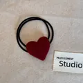 Detail view of a soft plush red heart hair tie with double black elastic bands. - Red Heart Hair Tie
