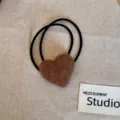 Close-up of a fuzzy brown heart-shaped hair tie on a neutral fabric background - Light Coffee Heart Hair Tie