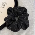 Close-up of black fuzzy scrunchie with gold metallic flecks and soft felt texture - Black Gold Thread Scrunchie