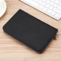 Portafoglio lungo RFID in vera pelle nera con cerniera su una scrivania in legno chiaro. - Full Grain Leather / Nero