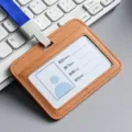 Professional brown leather ID badge holder with blue lanyard shown on office keyboard - Horizontal / Brown
