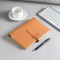 Braune Leder-A5-Loseblatt-Notizbuchhülle mit Schnalle in einer minimalistischen Büroumgebung - A5 / Braun