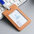 Premium brown leather ID badge holder with blue lanyard shown on computer keyboard - Vertical / Brown