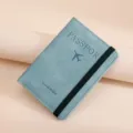 Light blue PU leather passport holder with black elastic band variant for travel. - Light Blue