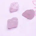 Vista dettagliata di tre pietre di cristallo grezzo di quarzo rosa naturale per gioielli - Quarzo rosa