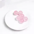 Piccole sfere di cristallo di quarzo rosa naturale su un piatto decorativo - Sfera di Quarzo Rosa