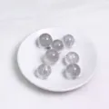 Set di 7 sfere di cristallo naturale esposte su un elegante piatto di ceramica bianca - Sfera di Cristallo Bianco