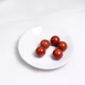 Cinque sfere di cristallo di diaspro rosso lucido su un piccolo piatto di ceramica. - Sfera di Diaspro Rosso
