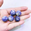 Sfere di cristallo di sodalite blu naturale tenute in mano con venature marmoree - Sfera di Pietra a Macchie Blu