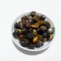 Polished natural tiger eye stones in a white bowl for home decor and DIY jewelry - Tiger's Eye / 100g Pack
