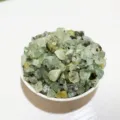 Polished natural green crystal gravel stones displayed elegantly in a white porcelain bowl. - Prehnite / 100g Pack
