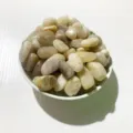 Polished natural light-colored crystal pebbles in a bowl for home and aquarium decor. - Orange Moonstone / 100g Pack