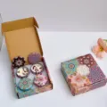 Vista detallada de un set de regalo de velas aromáticas con latas florales - Caja de regalo de 4 unidades / Fresia