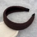 Gros plan d'un bandeau large en tricot marron avec texture torsadée pour l'hiver. - Serre-tête en Tricot Café