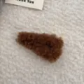 Detail einer braunen Plüsch-Haarklammer mit weicher Lammwolltextur auf Fleece-Stoff - Dreieck Plüsch BB Clip / Kürbisbraun