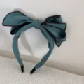 Detailansicht des eleganten blauen Stoff-Stirnbands mit großem Stereo-Schleifen-Design. - 3D Schleife Stil (FG89069) / Grün