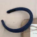 Vue détaillée d'un serre-tête rembourré en tricot bleu marine au style minimaliste. - 2.0cm / Bleu