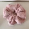 Nahaufnahme eines weichen, rosa flauschigen gestrickten Haargummis mit Wolltextur - Rosa Plüsch Scrunchie