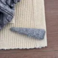 Close-up van de zachte grijze wollen textuur van een minimale driehoekige haarspeld. - Lichtgrijs