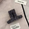 Nahaufnahme einer quadratischen Plüsch-Haarklammer aus dunkelgrauem Teddy-Stoff - Quadratischer Kleiderbügel-Stil / Grau