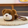 Cute brown plush bear toy keychain pendant with white snout and lanyard on woven mat - Prone Brown Bear