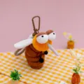 Adorable brown and orange cartoon mosquito plush keychain on a yellow checkered cloth - Mosquito