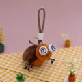 Süßer Insekten-Plüsch-Schlüsselanhänger mit Wirbelaugen und orangefarbenem Körper - Kakerlake