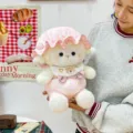 Adorable plush lamb toy wearing a pink sleeping cap and bib, held by a model in a cozy setting. - 25cm / Pink