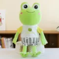 Soft green frog plush toy wearing a yellow T-shirt and striped shorts sitting on a basket - 35cm / Yellow Sleeves