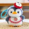 Adorable plush penguin keychain accessory with a blue hat and red apple bib detail. - Apple Style / 15cm