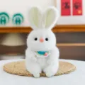Adorable white plush bunny toy with a blue crocheted collar displayed on a woven mat - Rabbit Figure / 18cm