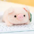 Adorable soft pink pig plush toy resting on a white keyboard, perfect desktop accessory - Pink Pig