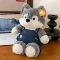 Niedlicher Husky-Plüschtier in Jeans-Latzhose auf Schreibtisch mit Laptop-Hintergrund - Wolf / 50cm