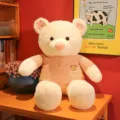 Large creamy white teddy bear wearing an orange knitted sweater in a cozy room setting - Pink / 100cm