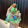 Green jellyfish shaped oil-filled acrylic keychain featuring a sailing boat and glitter - Green