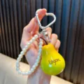 Schattige gele peer fruit sleutelhanger met parelkoord en een zilveren hartvormige haak - Perenlogo hangers