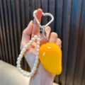 Creatieve mango sleutelhanger met witte parels en een hartvormige zilveren clip voor tassen - Mango