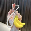 Schattige banaan sleutelhanger met hartvormige karabijnhaak en parelketting voor tassen. - Gele Banaan