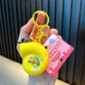 Adorable yellow music snail keychain toy with cute avocado print and pink decorative tag - Musical Snail / Yellow
