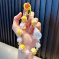 Gele en iriserende kralen telefoonriem met een grote decoratieve zeeschelp hanger - Geel / Inclusief Pakking