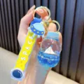 Kreativer Schlüsselanhänger mit blauem Segelboot in Flasche und Weltraum-Band-Design - Milchflaschen-Stil