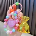 Levendige kralen sleutelhanger met roze hart hanger en gouden geldzakje bedel. - Kleurrijke kralen gelukstas / Geel