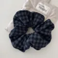 Primer plano de un coletero retro de tela con patrón de pata de gallo gris - Coletero a Cuadros Azul Oscuro