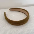 Detail view of an olive brown sponge headband with ribbed texture on white fabric. - Yellow Headband